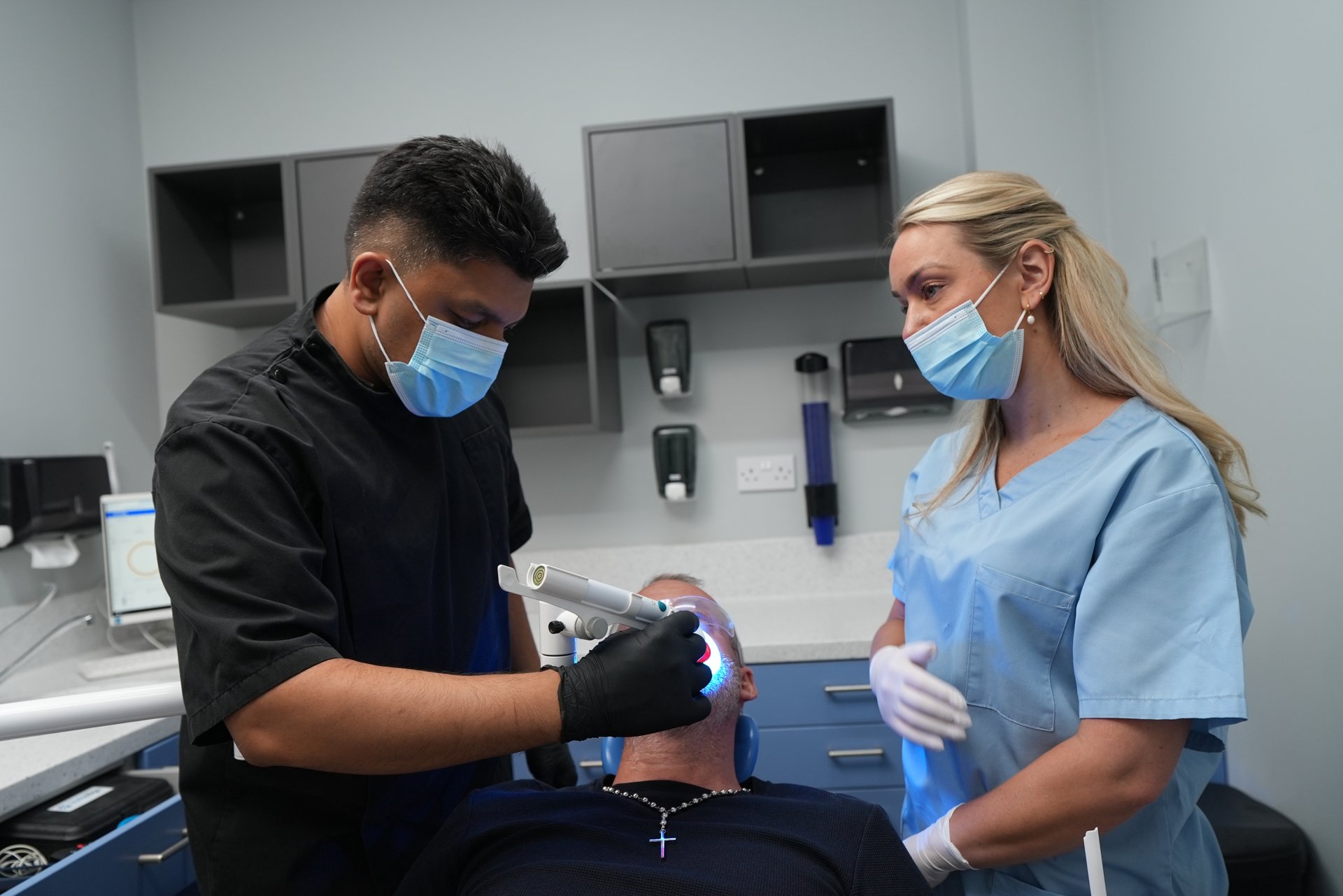 Dentist and dental nurse treating a patient together