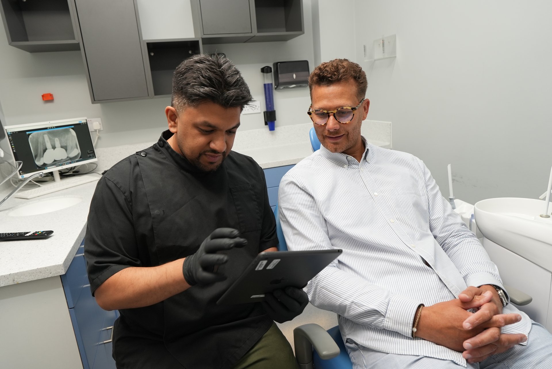 Dentist reviewing a patient's symptoms on a tablet